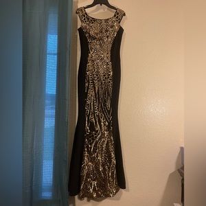 A color black dress with golden details vertically in the middle of the dress.